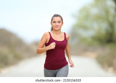 Front view portrait of a runner jogging towards camera in the mountain