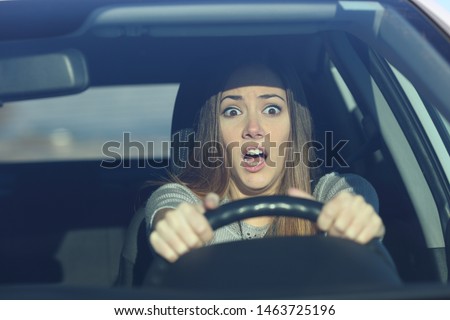 Front view portrait of an scared driver driving a car before an accident