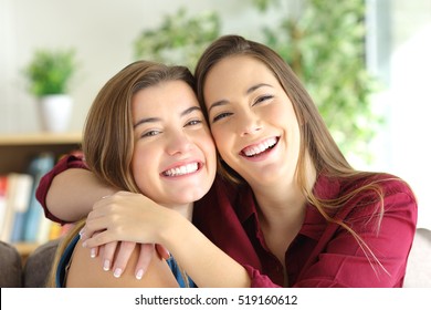 Front View Portrait Of A Two Happy Friends Or Sisters Posing Smiling And Looking At You With A Homey Background