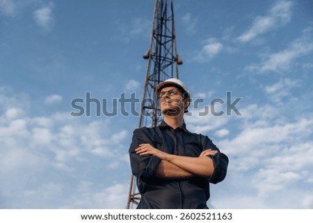 Front view, posing and standing with arms crossed. Construction worker is near boring drilling machine.