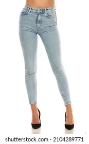 Front view of pretty female legs in jeans and shoes on white background