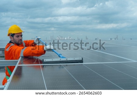Front view profession engineer or technician worker use cleaning brush to clean solarcell panel in area of rooftop of building.