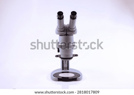 Front view of a professional binocular stereo microscope isolated on a white background. Optical laboratory equipment used for inspection, biology, electronics and scientific research.
