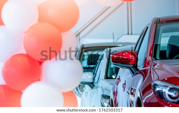 Front view of red SUV car in showroom. New luxury\
car parked in modern showroom for sale. Car dealership office.\
Automobile retail shop. Electric car technology and business.\
Automobile rental.