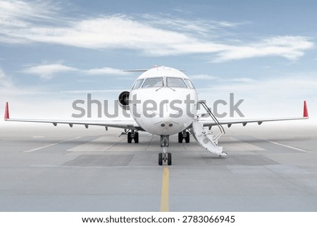 Front view of the regional jet with an opened gangway isolated on bright background with sky