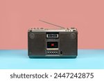 Front view, Retro outdated portable stereo boombox radio cassette recorder on colorful background, vintage old cassette radio with antenna on mint blue floor.