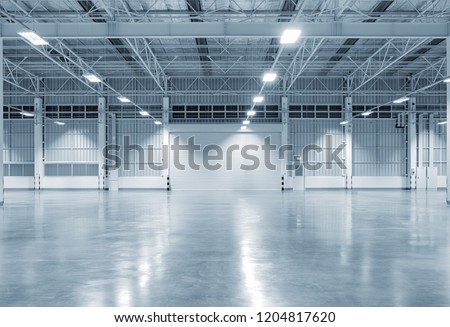 Front view of a roller door (roller shutter), an essential entrance and security feature for commercial buildings, factories, warehouses, and aircraft hangars. This type of industrial door is widely used in logistics, manufacturing, and storage facilities for secure access control and operational efficiency.

The scene showcases a modern industrial interior with a clean, smooth polished concrete floor, reflecting a well-maintained and professional environment. The closed roller shutter emphasizes safety, protection, and restricted entry, key elements in warehouse management, distribution centers, and industrial operations.

The space is presented in a dark gray tone with a subtle soft blue tint, creating a contemporary and slightly dramatic industrial atmosphere. This color palette enhances depth and contrast, making the setting ideal for advertising, branding, and product presentation.

With its open layout and minimal design, the environment works perfectly as a background for product display, including automobiles, car showcases, boats, machinery, or equipment. The neutral backdrop allows products to stand out clearly, making it suitable for automotive marketing, commercial promotions, and showroom-style visuals.

This image highlights key aspects of architecture, such as metal roller shutters, warehouse entrances, loading bays, and large-scale storage spaces. It also represents important concepts in logistics, supply chain management, manufacturing, and engineering, where durable and secure entry systems are essential.

The polished concrete floor adds a sense of cleanliness, durability, and modern design, often associated with high-end factories and contemporary commercial spaces. The closed shutter combined with the empty floor space provides flexibility for creative compositions, product placement, and marketing use.

Overall, this image is ideal for themes related to business, warehouse interiors, factory environments and commercial real estate.