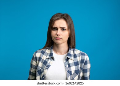 Front view of sad young woman looking at camera isolated on blue background. - Shutterstock ID 1602142825