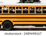 Front view of schoolchildren classmates pupils looking out of the school bus waiting for new educational year semester, coming back to school lessons and homework.