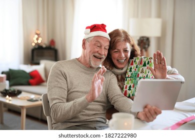 Front view of senior couple indoors at home at Christmas, having video call with family. - Powered by Shutterstock