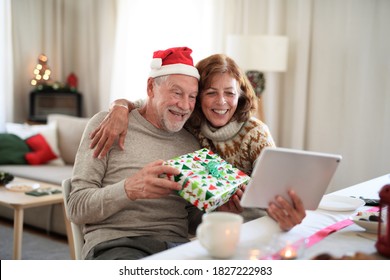 Front view of senior couple indoors at home at Christmas, having video call with family. - Powered by Shutterstock