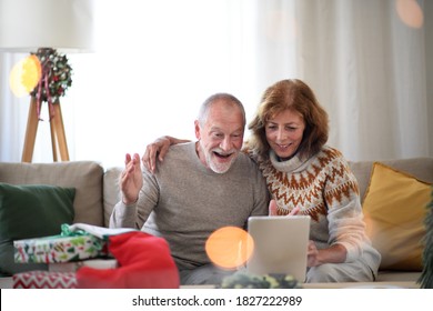 Front View Of Senior Couple Indoors At Home At Christmas, Having Video Call With Family.