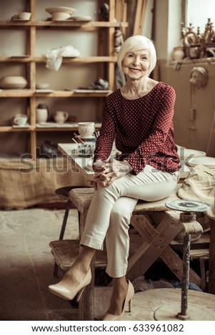 Similar – Woman in work wear in her workshop by table with handmade items