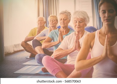 Front View Of Seniors Relaxing With Fitness Instructor In Retirement House