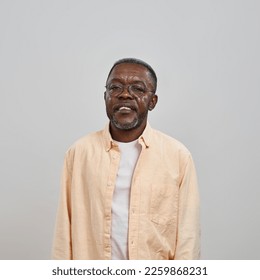 Front view of serious senior black man looking at camera. Male person wearing glasses and casual clothes. Concept of modern elderly lifestyle. Isolated on white background. Studio shoot. Copy space - Powered by Shutterstock