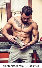 Front View Of Sexy Muscular Topless Man In Kitchen At Home Making Coffee, Wearing Only Boxer Shorts, Showing Big Muscles