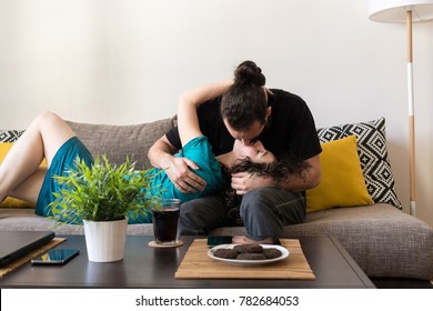 Front view shot of an affectionate young couple kissing on the sofa at home. Everything is spinning when we kiss