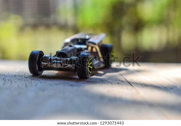 \
Front view of\
a small car toy on a wooden\
table