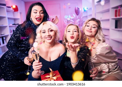 Front view of a smiling woman enjoying her birthday party with her pleased female friends