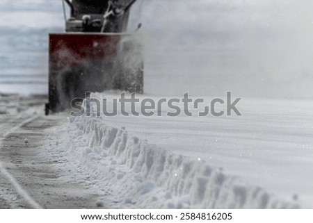 front view of a snowblower in action after a storm with snow churning in impeller blade. winter season weather background design element.