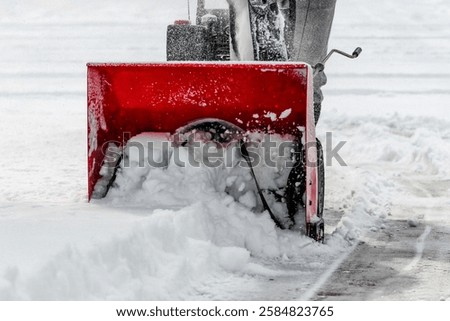 front view of a snowblower in action after a storm with snow churning in impeller blade. winter season weather background design element.