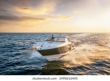 Front view of a sports motor boat cruising with high speed over the blue sea during summer sunset time