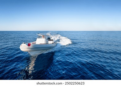 Front view of a sports RIB boat cruising with high speed over the blue sea, with copy space