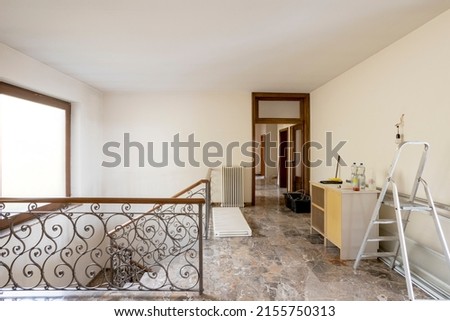 Front view of staircase with iron railing and trash on left. Interior of vacant old villa to be refurbished. Nobody inside
