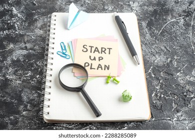 front view start up plan note on sticker with pen and magnifier on gray background lesson student note paper study sticker notepad school
