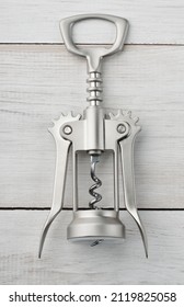 Front View Of Steel Winged Corkscrew Bottle Opener On White Wooden Background