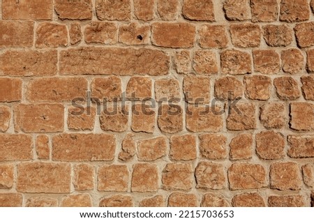 Front view of  stone wall background. Stones are light orange in color.