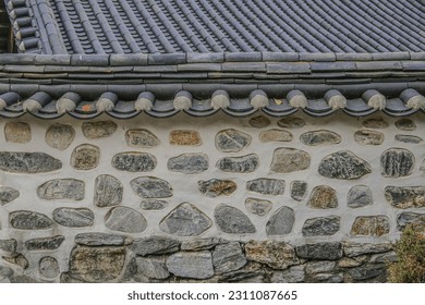 Front view of stonewall and tile roof of a tile-roofed house at Namsangol Hanok Village of Pil-dong near Jung-gu, Seoul, South Korea
