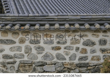 Front view of stonewall and tile roof of a tile-roofed house at Namsangol Hanok Village of Pil-dong near Jung-gu, Seoul, South Korea
