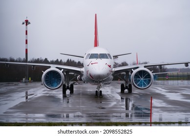 Front View Of Tationary Helvetic Airways Airplane With Covered Flight Engines At Zürich Airport On A Rainy Winter Day. Photo Taken December 28th, 2021, Zurich, Switzerland.