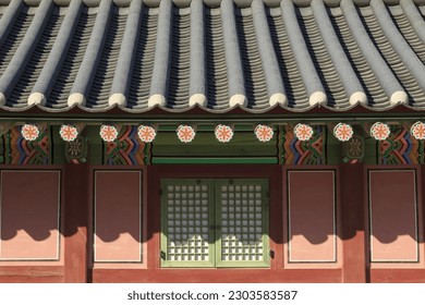 Front view of tile roof and Dancheong(multicolored paintwork) with window door and wall of a house at Gyeongbokgung Palace, Seoul, South Korea
				
