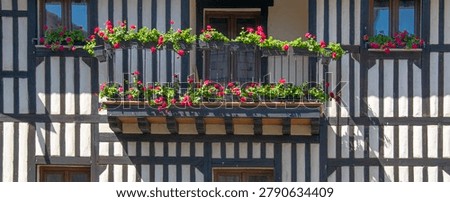 | Front view of timber framed facade decorated with colorful flower boxes in traditional village architecture of La Alberca Salamanca Spain