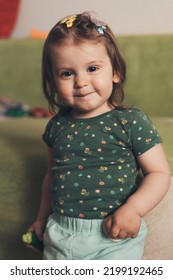 Front View Of A Toddler Girl Smiling Confident Having Fun, Standing At Home Looking At Camera. Smiling Happy Child. Child Care. Apartment Interior. Smiling Girl