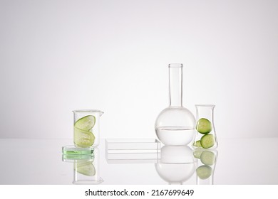 Front View Of Transparent Podium With Laboratory Equipment And Cucumber In White Background Science Content