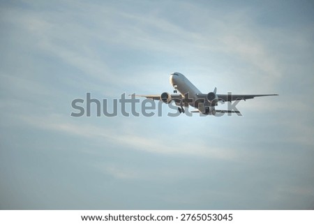 Front view of a twin-engine passenger airplane on final descent with landing gear down, flying through a soft clouded sky, suitable for aviation, travel, and global transportation themes.