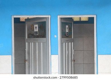 Front view of two adjacent public school toilets for men (marked with 