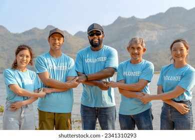 front view of volunteer team holding each other's crossed hands for unity and teamwork in a nature environment, group of diverse people had handshake together in line engage in work for society - Powered by Shutterstock