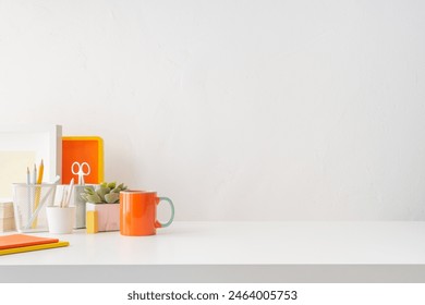 Front view white desk with supplies, alarm clock, coffee mug and copy space. - Powered by Shutterstock