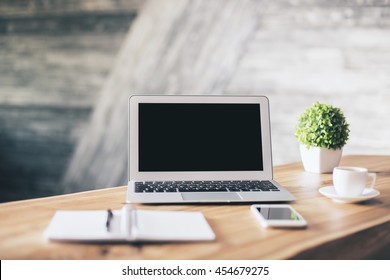 Front View Of Wooden Designer Workplace With Blank Laptop, Stationery Items, Coffee Cup, Cell Phone And Plant. Mock Up