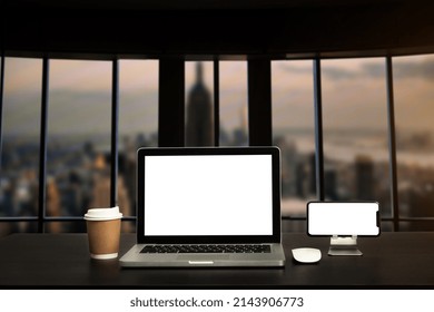 Front view workspace with computer, smartphone and tablet on white desk with blurred background as concept