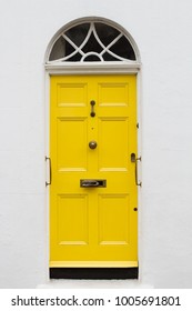 Front View Of Yellow Elegant Residential Apartment Door With Glass Window And Metallic Vintage Mailbox