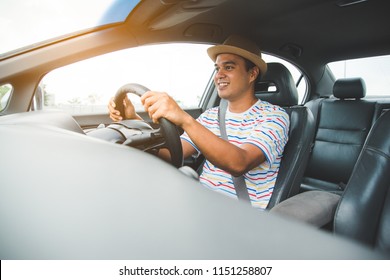 Front View Of Young Asian Man Driving Car.