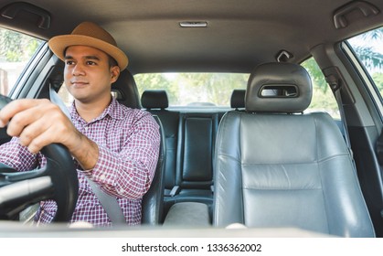 Front View Of Young Asian Man Driving Car.