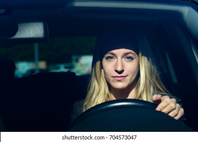 Front View Of Young Blond Woman Smiling While Driving Car