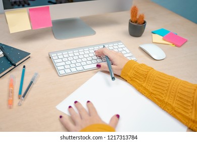 Front of view of a young business woman working on her beautiful workspace with colorful notepads. Morning at a creative studio. Graphic design, mock up screens. glasses, pens, keyboard, notebook. - Shutterstock ID 1217313784