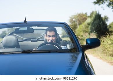 Front View Of A Young Man Driving His Convertible Car